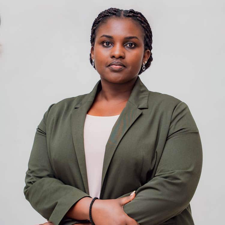 Pamela Bigirimana, Head of Strategic Partnerships at ARC Power, wearing an ARC Power polo shirt and glasses, smiling outdoors with a blurred green background