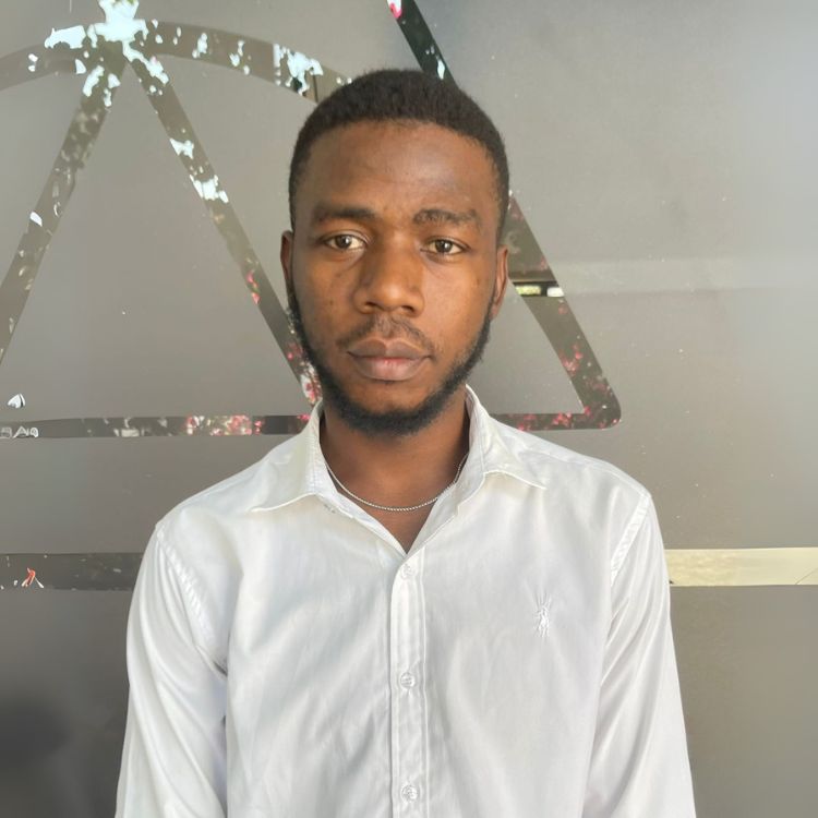 Alick Kakoma Finance Assistant at ARC Power Zambia, in a photography studio wearing a white shirt looking confidently at the camera